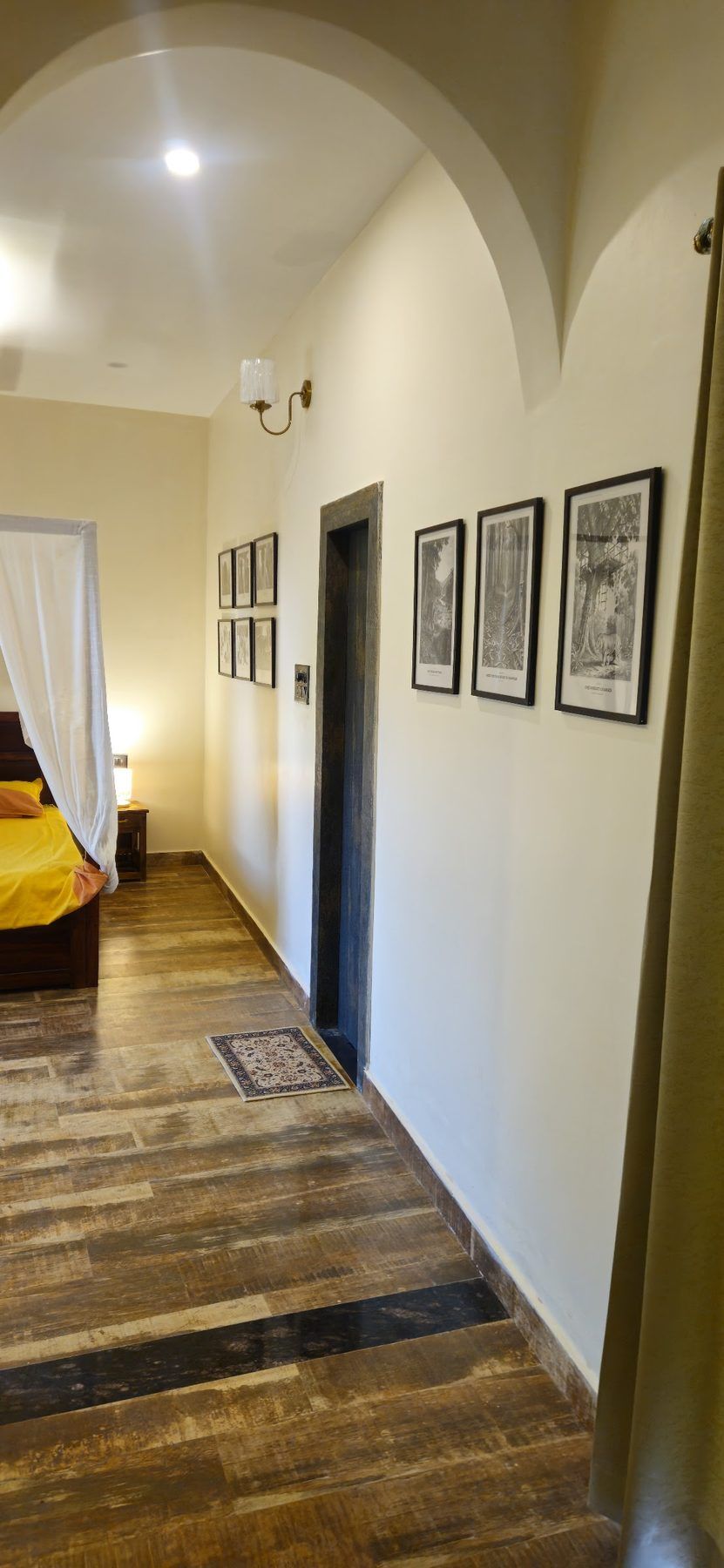 Cottage corridor with wooden floor and framed Palamu engravings