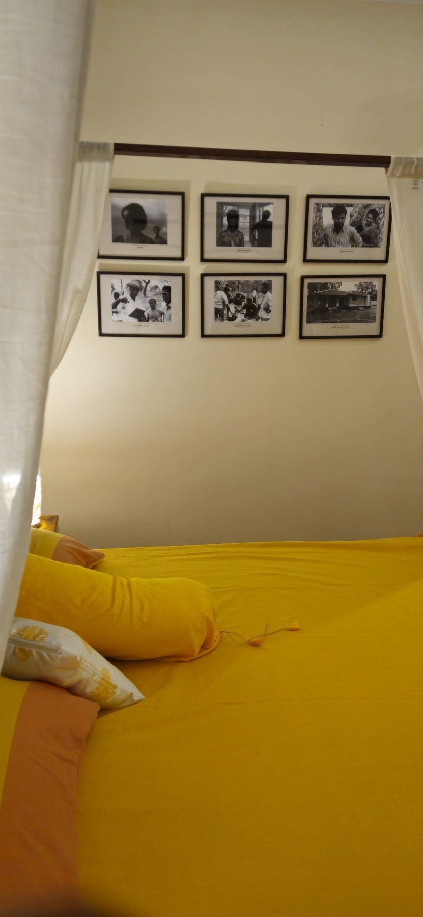 Bed beneath framed engravings