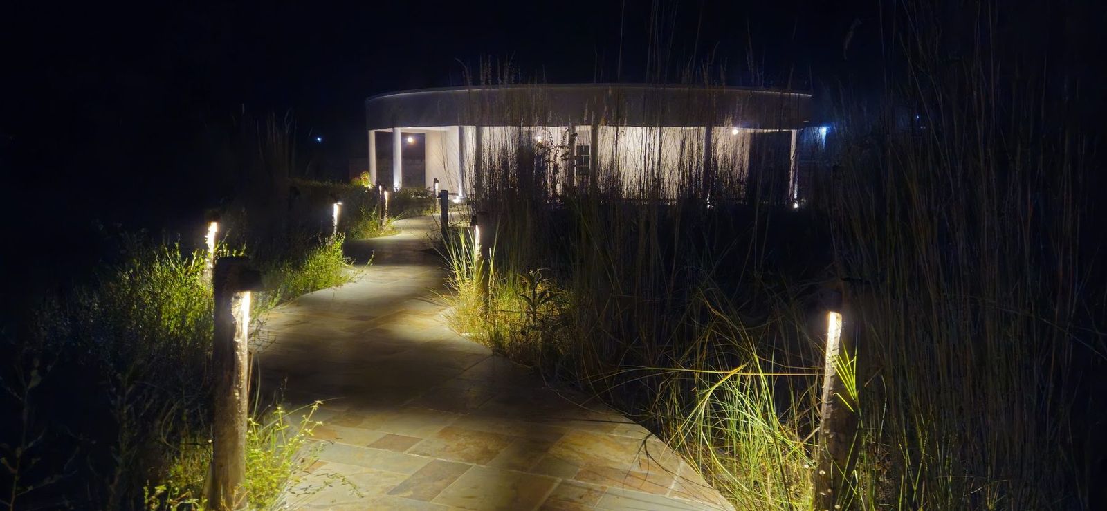 A lamp-lit path to a cottage at night